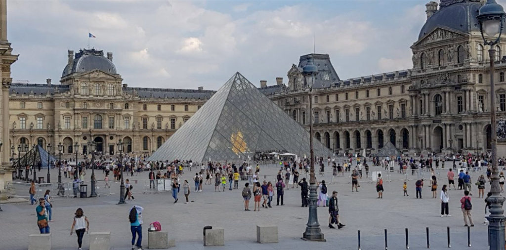 The Louvre Pyramid with a crowd of people
